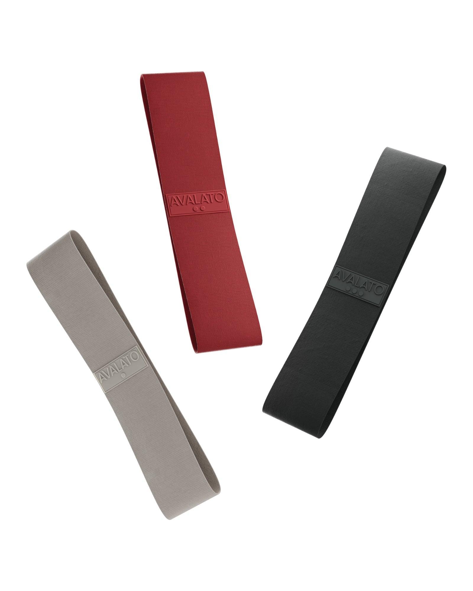 Set of three resistance bands for glutes in grey, red, and black, floating