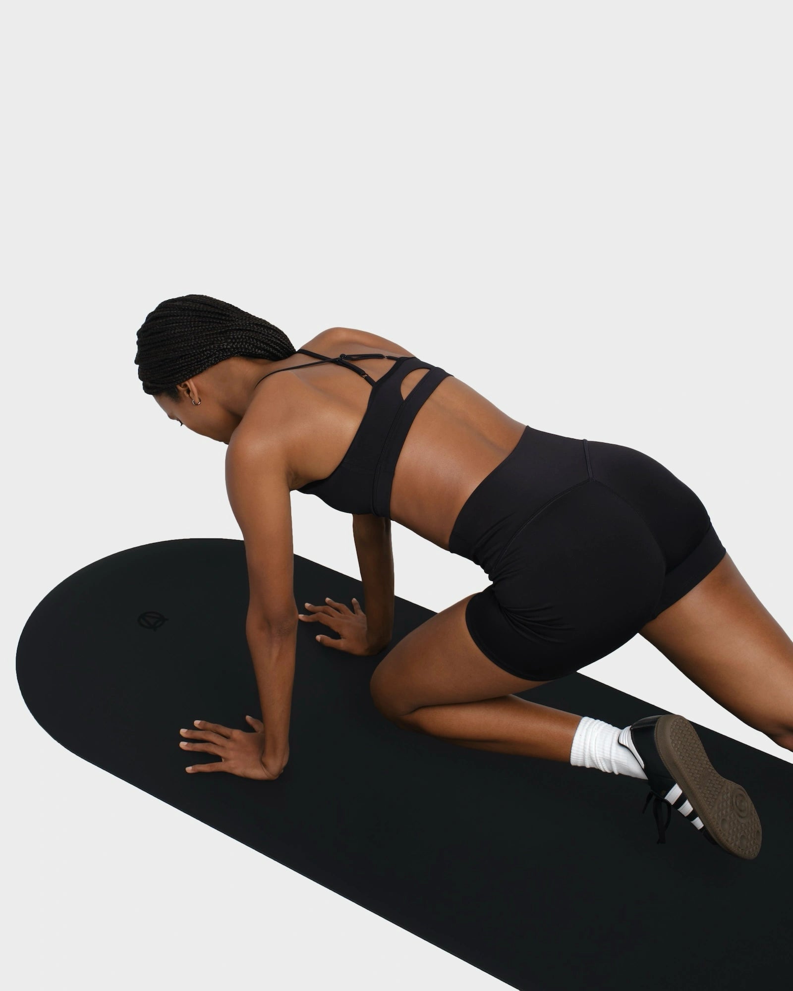 Woman doing abs workout on a black exercise mat