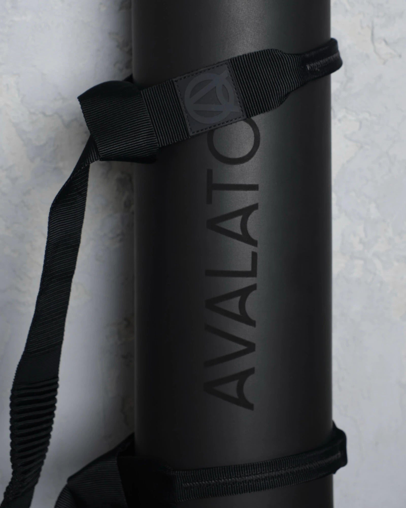 Close-up of a black exercise mat with a black carrying yoga strap