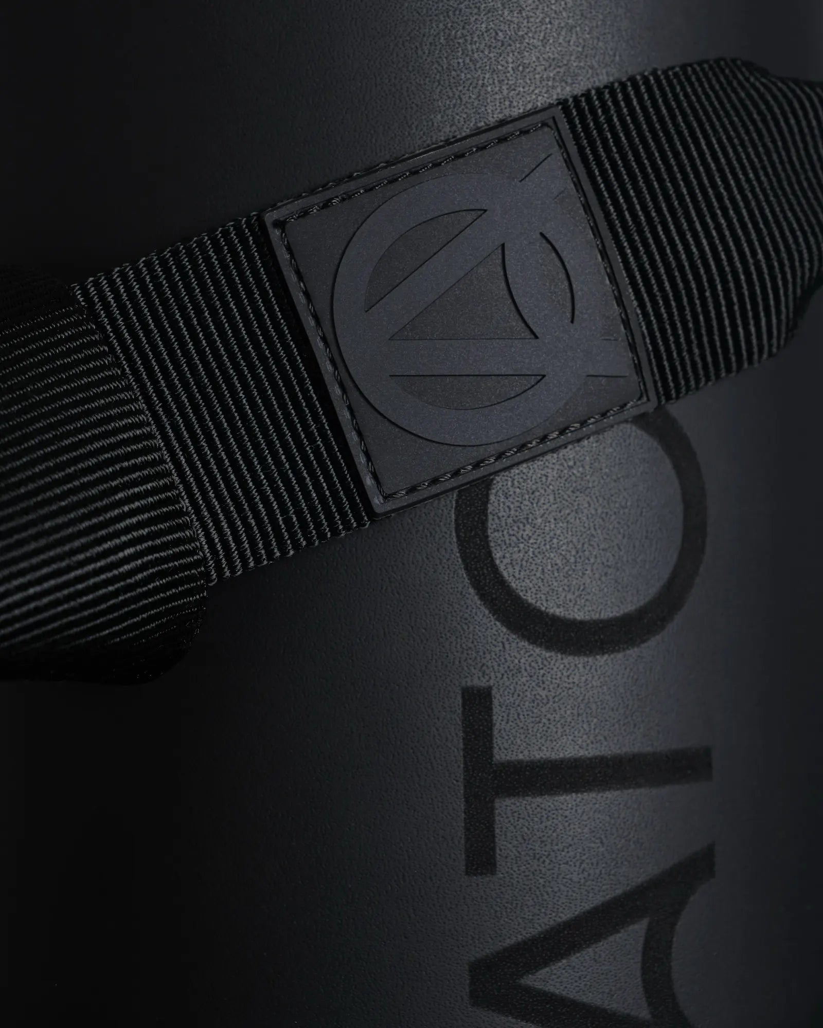 Detailed close-up of a black exercise mat with a black carrying yoga strap