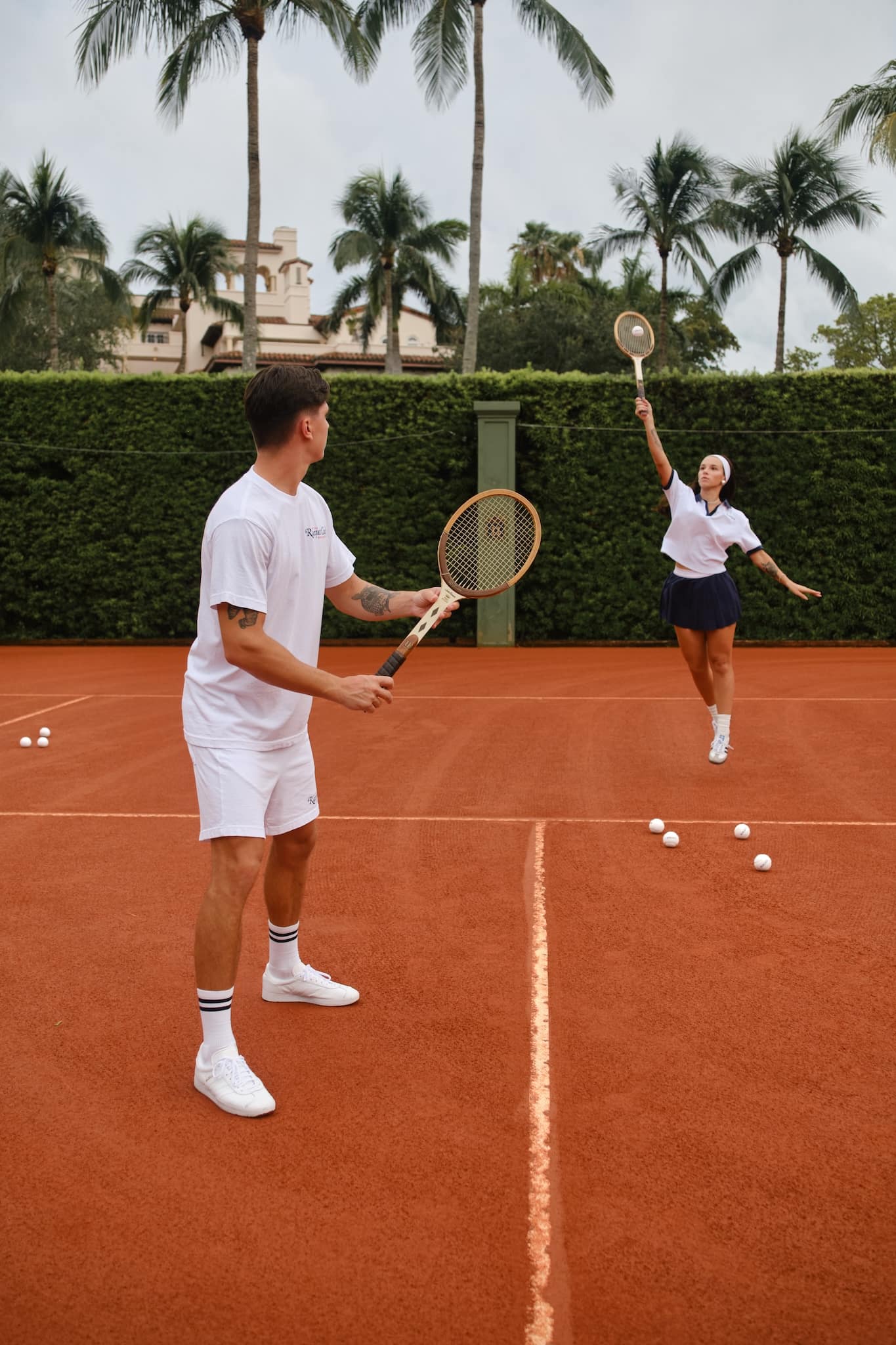 Two tennis players in the racquet club, playing mixed doubles with vintage white balls