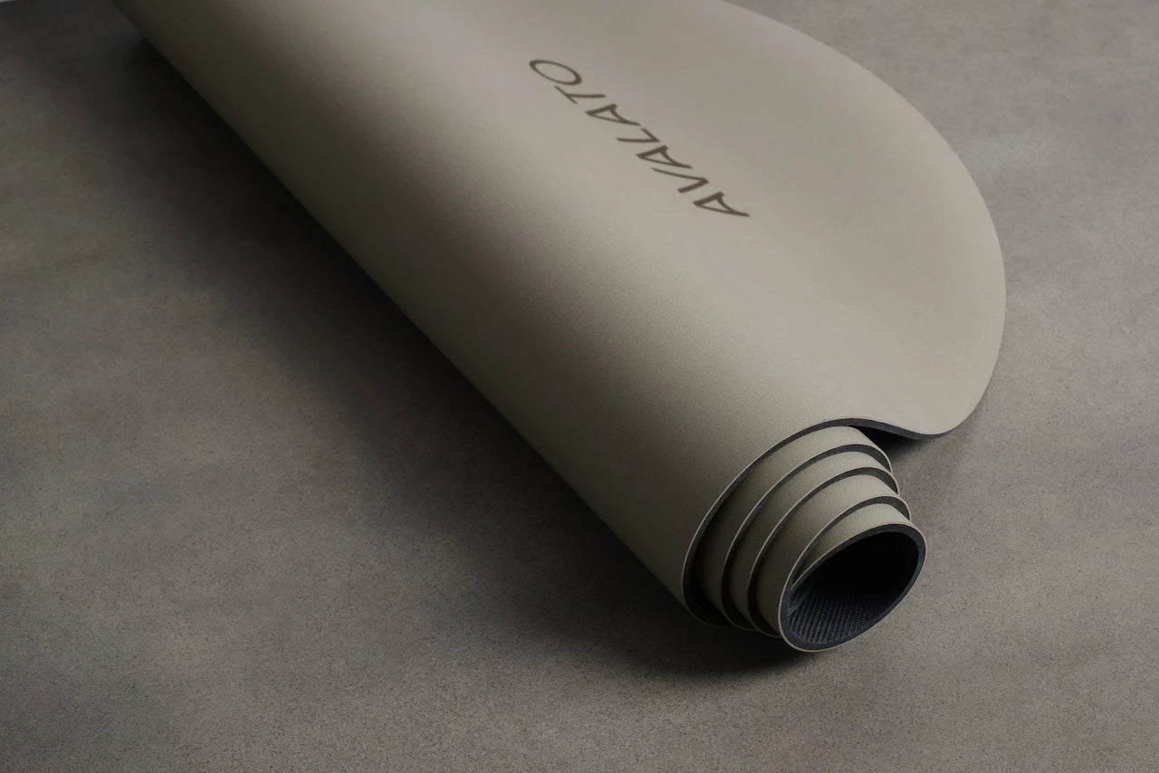 Avalato yoga mat made of natural rubber and leather rolled-up on the table