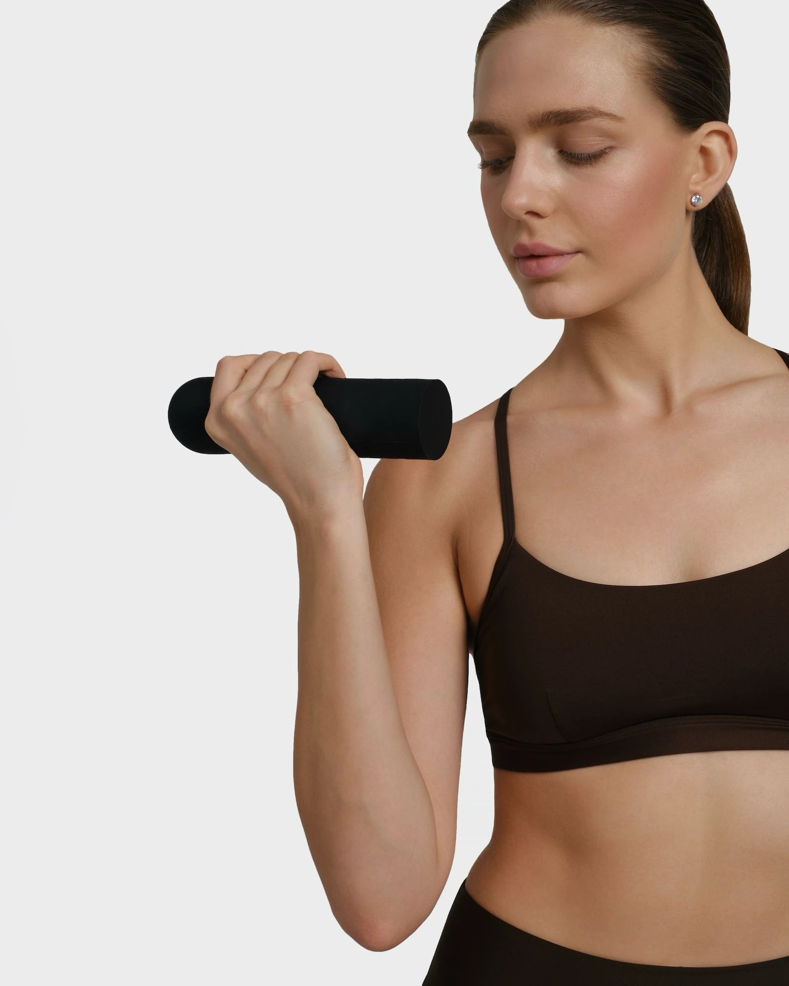 Close-up of a woman holding a black dumbbell doing workout routine